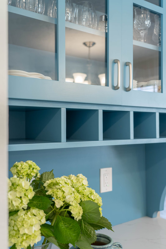 Blue hutch with mail slots and hydrangea flowers