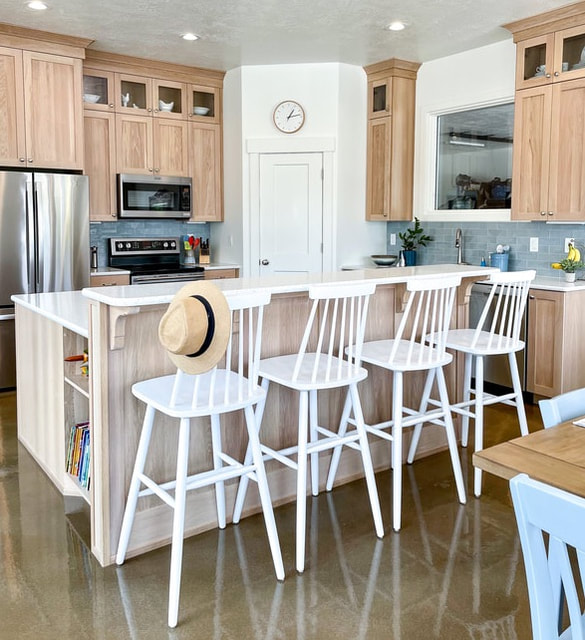 Beach side kitchen with white oak cabinets and blue backsplash